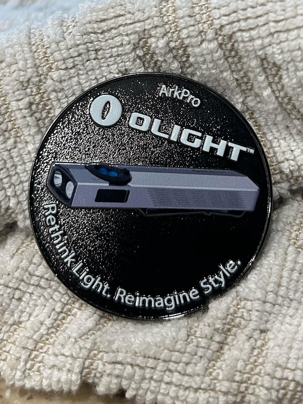 This is the Olight × B&H Photo ArkPro Challenge Coin